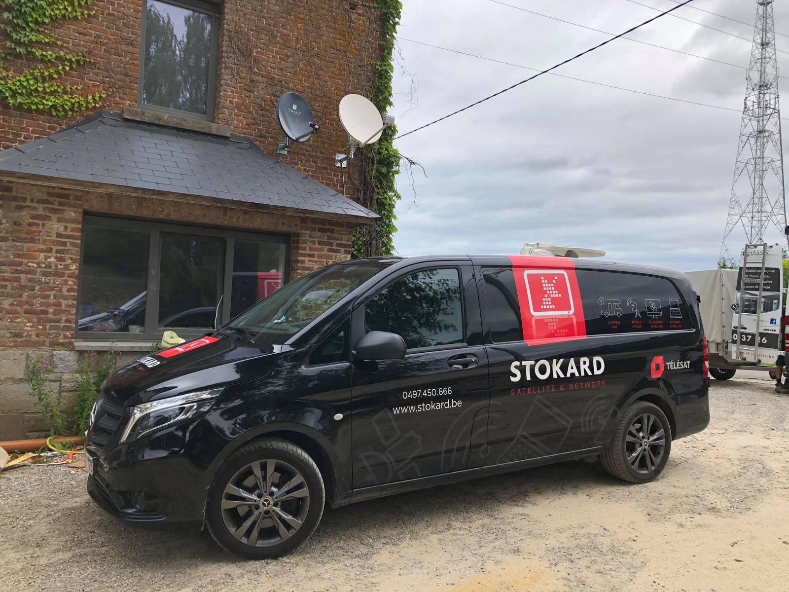Paraboles TV installées par Stokard sur une façade, devant la camionnette Stokard